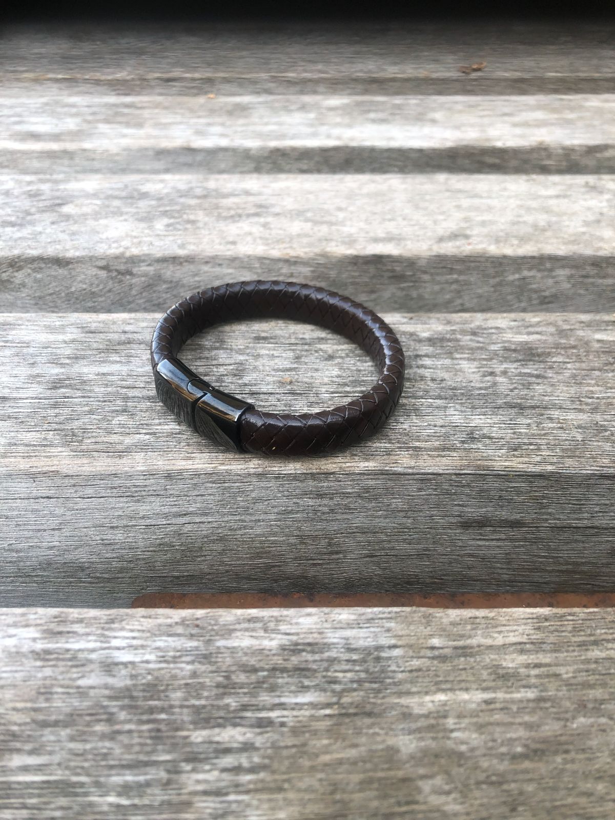 Brown leather bracelet on a wooden surface