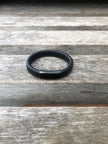 Black leather bracelet on a wooden surface