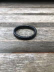 Black leather bracelet on a wooden surface