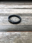 Black leather bracelet on a wooden surface