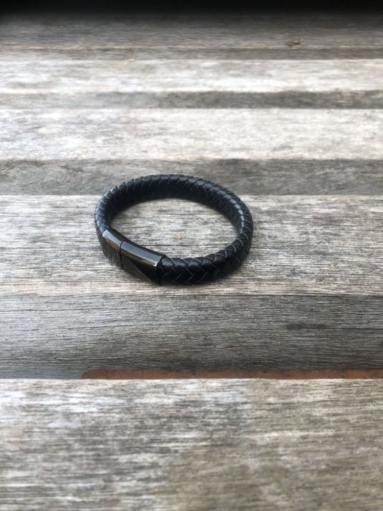 Black leather bracelet on a wooden surface