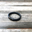Black leather bracelet on a wooden surface