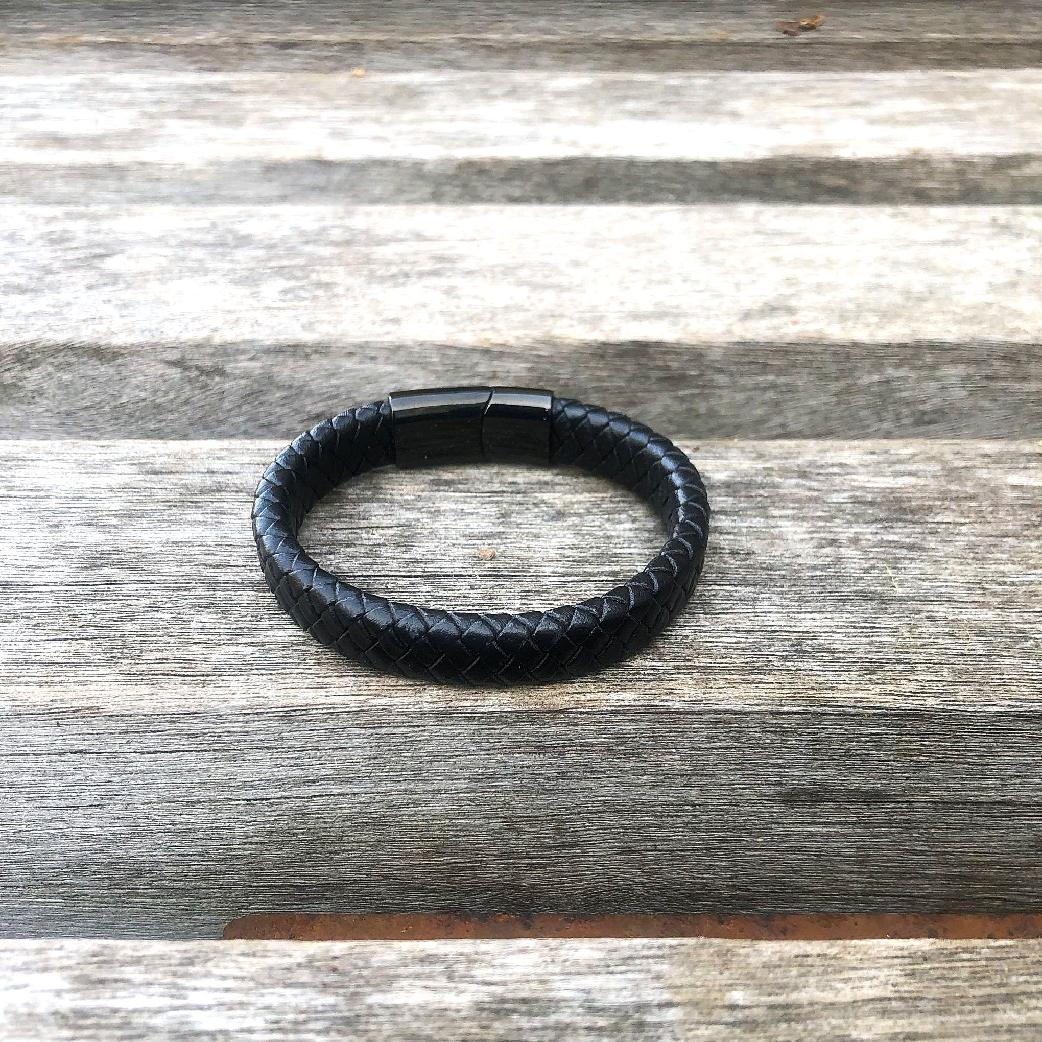 Black leather bracelet on a wooden surface