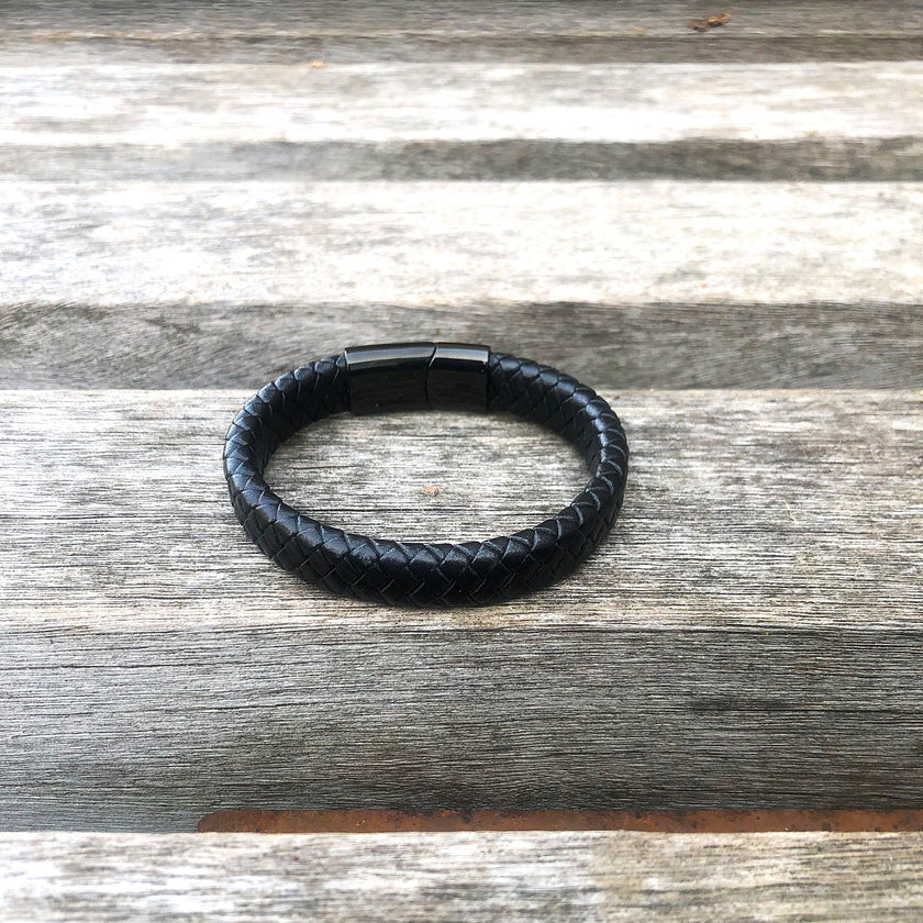 Black leather bracelet on a wooden surface
