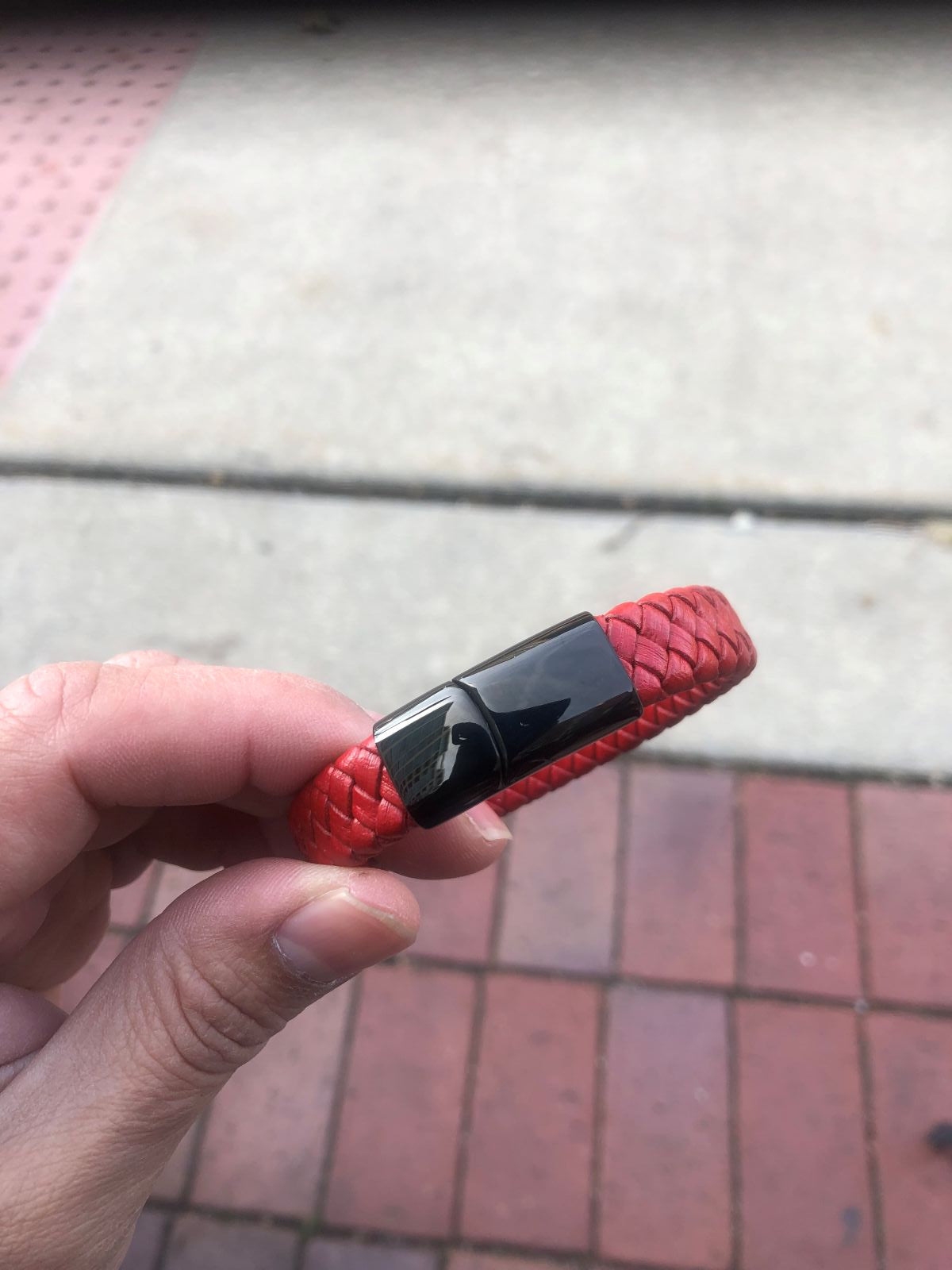 Red textured USB drive held in a hand with a blurred background