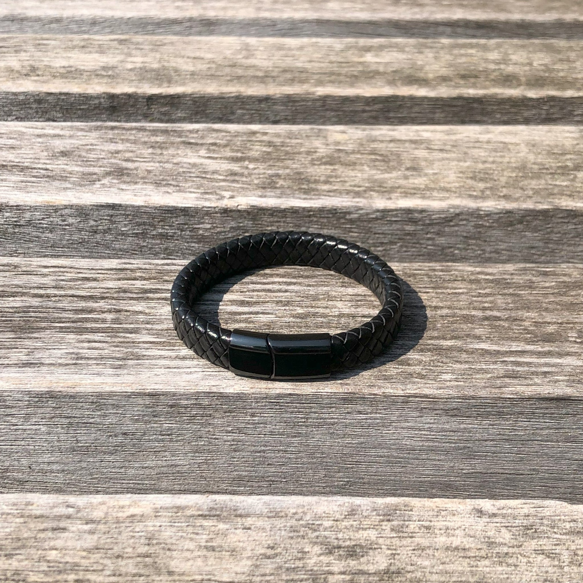 Black leather bracelet on a wooden surface