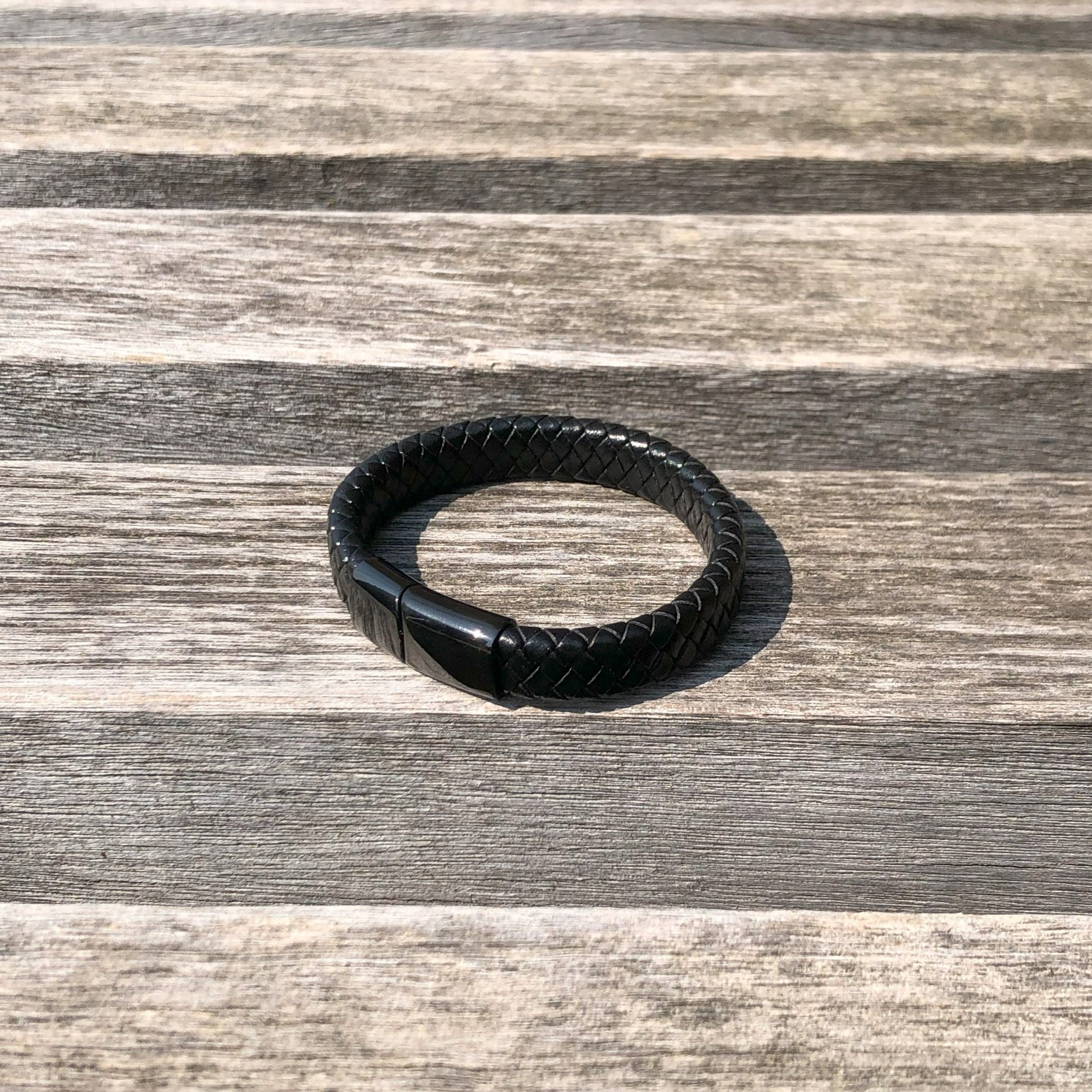 Black leather bracelet on a wooden surface