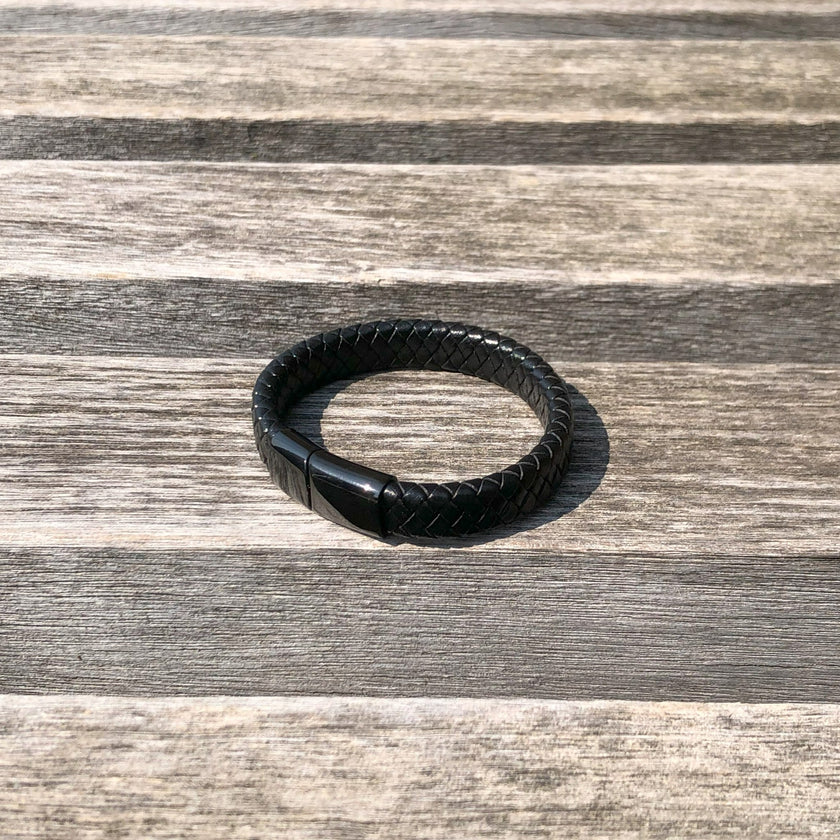 Black leather bracelet on a wooden surface