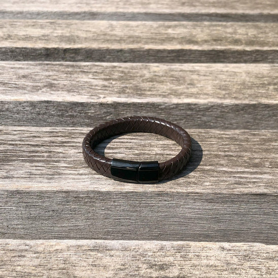 Brown leather bracelet on a wooden surface