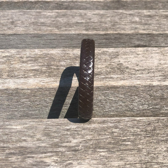 Brown leather strap on a wooden surface