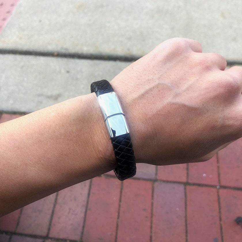 Black bracelet on a wrist with a blurred background