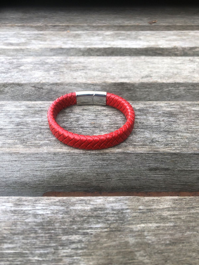 Red braided leather bracelet on a wooden surface