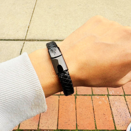 Men’s black braided leather bracelet worn on wrist
