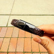 Men’s brown braided leather bracelet held in hand
