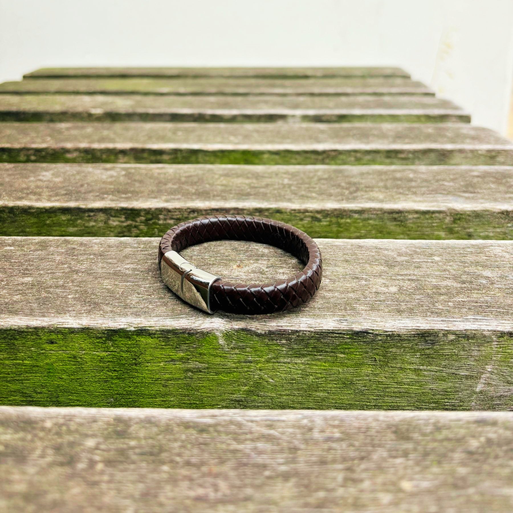 Men’s brown braided leather bracelet with polished stainless steel clasp angled view